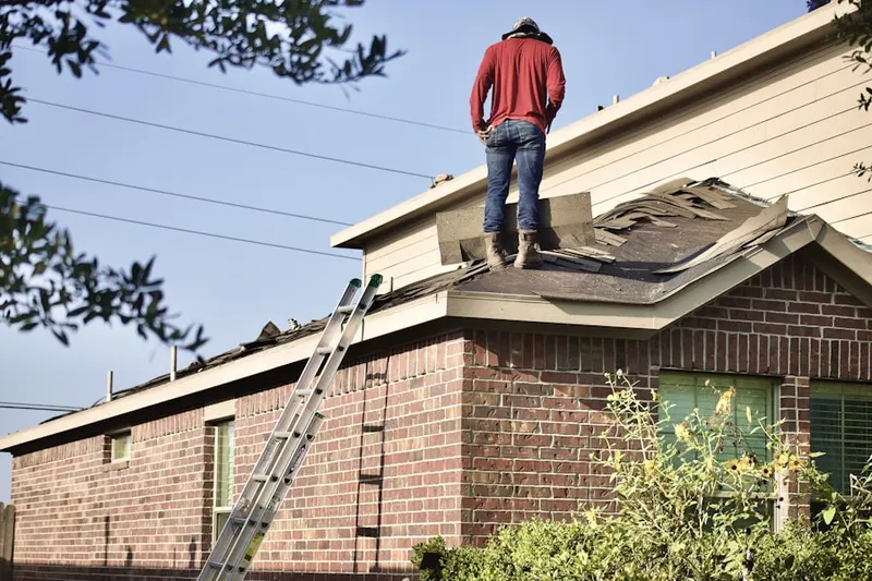 Professional roofer working on a residential roof in Thomas Forest